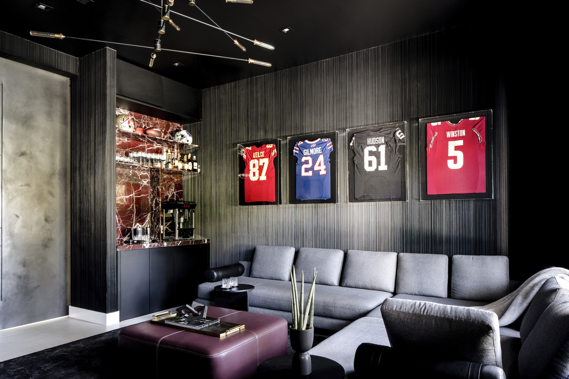 Sporting memorabilia in a living room interior designed by Eilyn Jimenez at the home of Erik Rodriguez “EJ” Manuel Jr in Effect Magazine