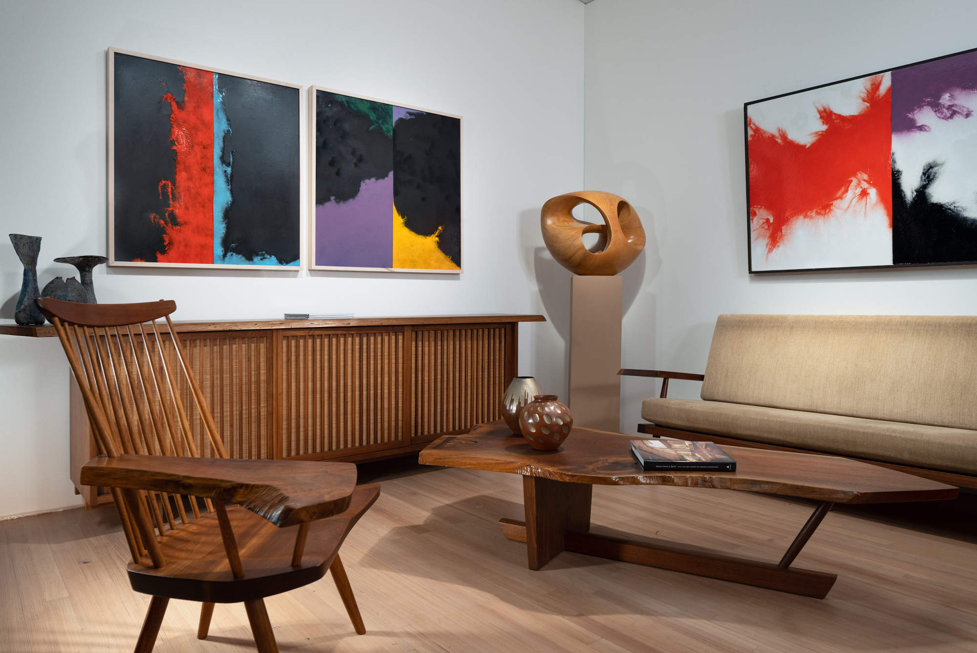 The Moderne Gallery booth at Salon Art + Design, with George Nakashima's Minguren II coffee table, armchair and wall-hung cabinet, and enamel abstract paintings by Paul Hultberg in Effect Magazine