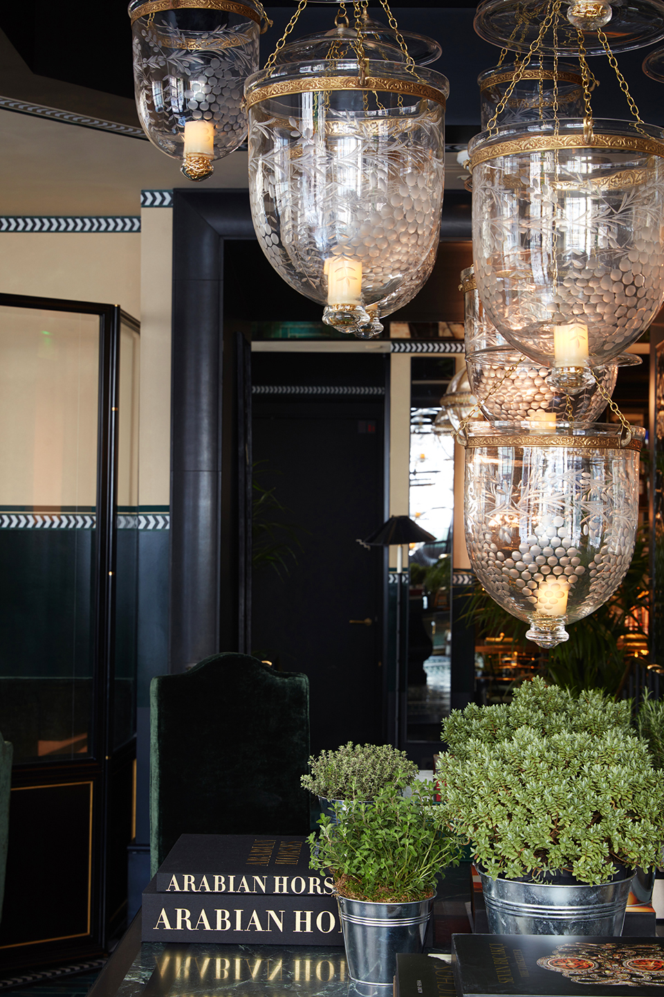The lobby of Monsieur George, interior designed by Anouska Hempel, with abundant plants, Moroccan hanging lanterns and marble doorways – Effect Magazine